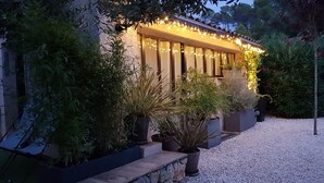 Un bâtiment doté d’une façade en pierre, de nombreuses fenêtres et d’un éclairage extérieur.