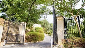 A gated entrance with a metal gate and a beige wall.
