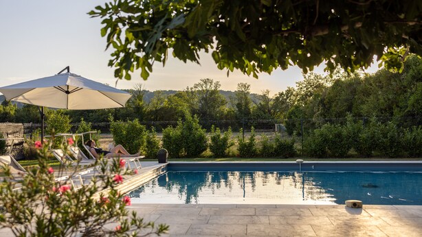 A swimming pool with lounge chairs and an umbrella, surrounded by greenery and trees. - Farmhouse fully renovated in provence - Superb swimming pool 9m X 9m (Cavaillon)