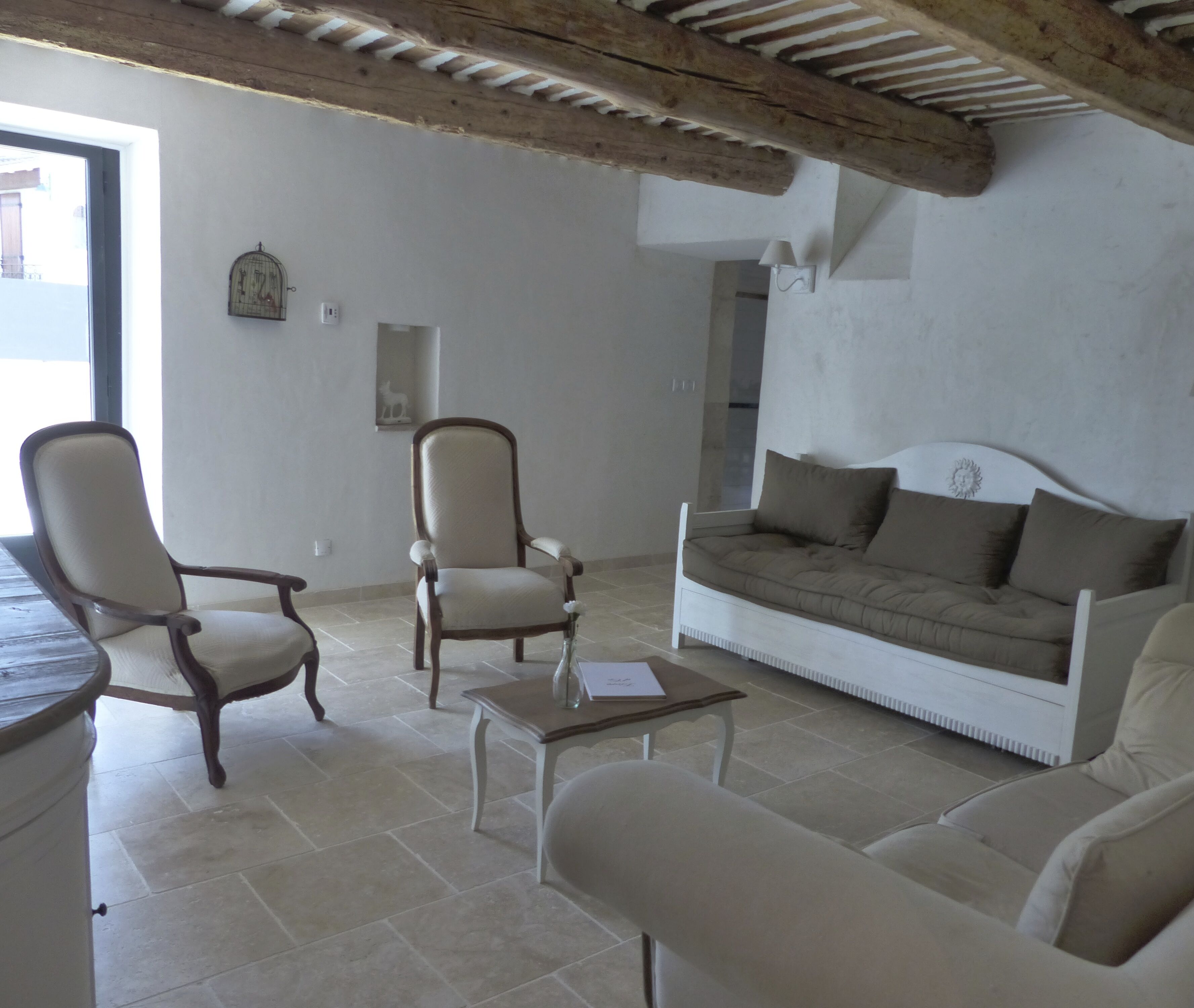Una sala de estar con techo de madera, un sofá, una silla y una mesita.