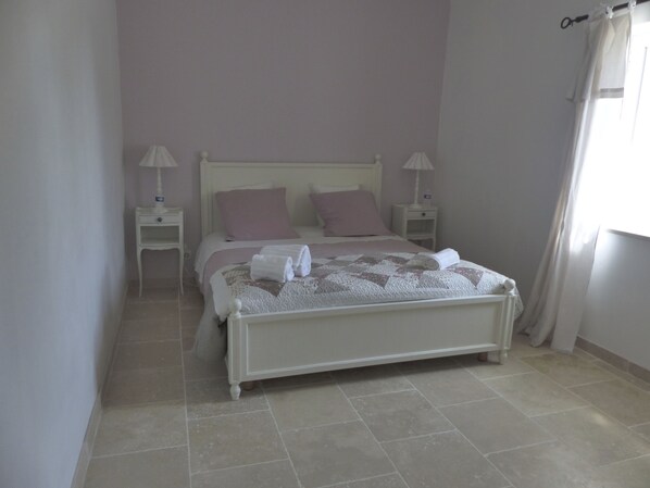 A neatly made bed with white and pink linens, two bedside tables with lamps, and a window with curtains. - Farmhouse fully renovated in provence - Superb swimming pool 9m X 9m (Cavaillon)