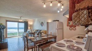 Un comedor con una mesa preparada para cuatro personas, un refrigerador y una estufa.