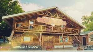 A rustic log cabin with a sign reading "Pickleville Playhouse 1977".