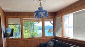 A cozy cabin-style room with a sectional sofa, a small table, and a television.