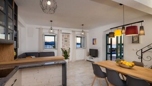 A modern kitchen with a dining area, a TV, and a view of the sea. - Holiday Home in Murvica with Seaview, Terrace, Air condition, WIFI (3756-1) (Murvica)
