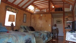A cabin with two beds, a dining area, and a kitchen.