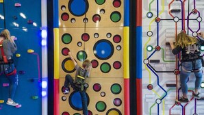 A climbing wall with colorful holds and a circuit-like design on the wall.