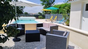 A pool area with a hot tub, outdoor furniture, and umbrellas. - La Réserve, 2/4 person duplex gite, 9x4 pool, Saintes / Royan / Oléron axis (Luchat)