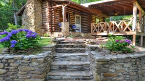 Una baita di legno con una scala in pietra che conduce a un pontile in legno.