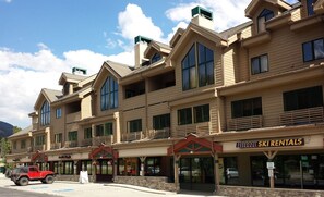 A multi-story building with a ski rental sign, large windows, and a red vehicle parked in front. - Walk to River Run • One of Keystone's Largest 4BR/4BA Penthouse (Keystone)