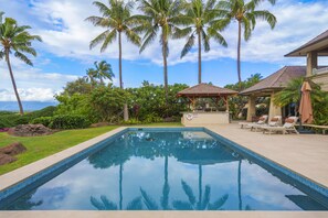 A swimming pool with a tiled edge, surrounded by palm trees and a gazebo. - Luxury, Beachfront- Ka'anapali Beach, Pool & Hot Tub! (Lahaina)