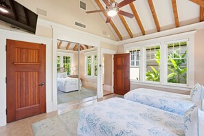 A bedroom with a large mirror, wooden doors, and a ceiling fan.