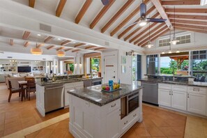 A spacious kitchen with a central island, white cabinetry, and a ceiling with exposed wooden beams. - Luxury, Beachfront- Ka'anapali Beach, Pool & Hot Tub! (Lahaina)
