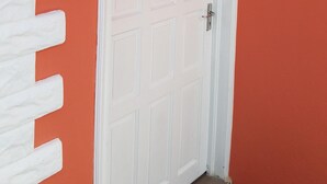 A white door with a textured white wall on the left. - Private 1 bedroom, modern  self contained   cottage in the heart of Soufriere  (Soufriere)