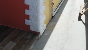 A building with a red door and two windows with white frames. - Private 1 bedroom, modern  self contained   cottage in the heart of Soufriere  (Soufriere)