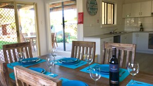 A dining area with wooden chairs and a table set for four with blue placemats and plates.
