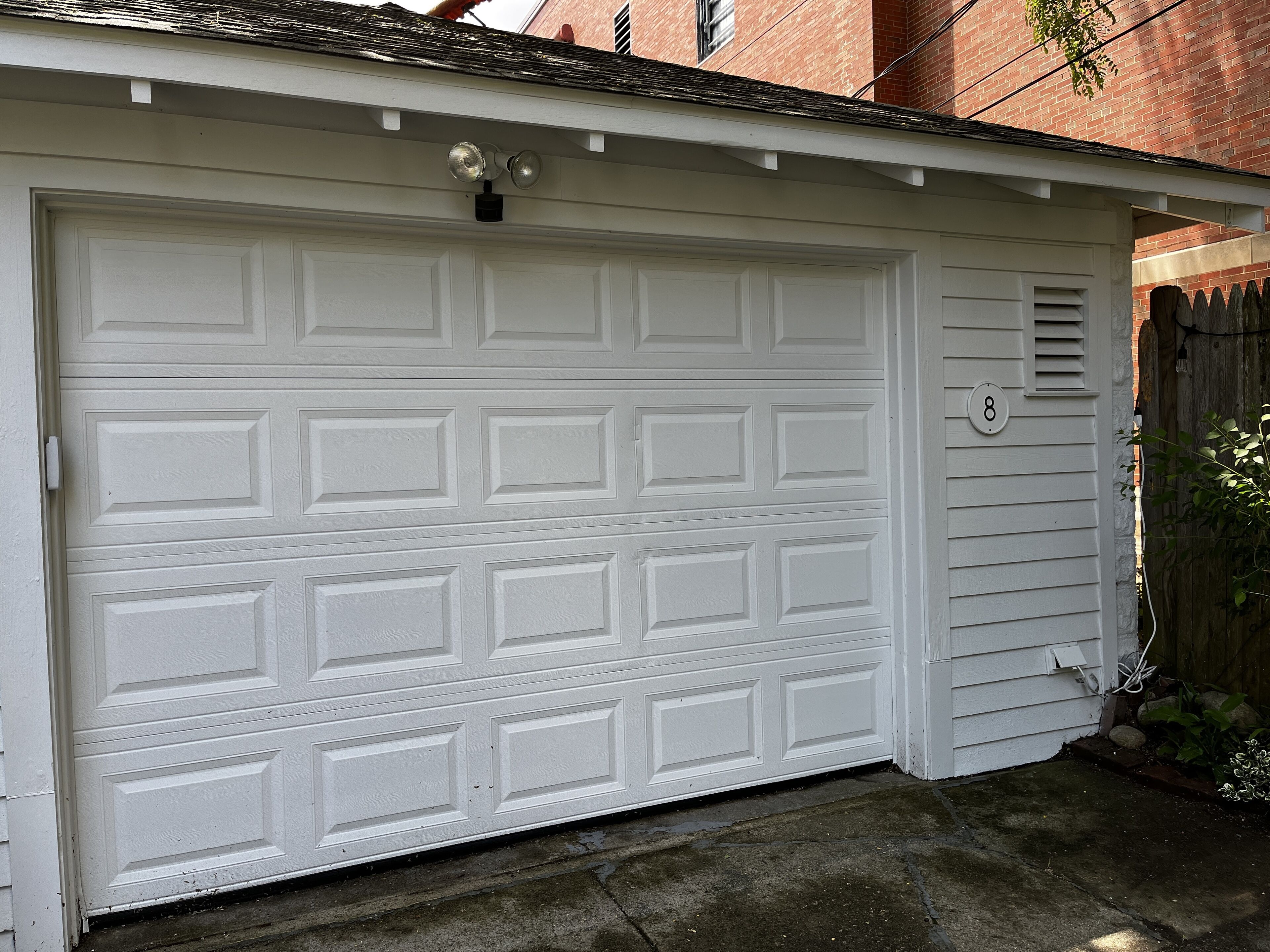 Une porte de garage blanche avec le chiffre « 8 » sur le côté droit.