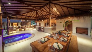 A spacious indoor area with a pool, a dining table set for a meal, and a kitchen area. - 2 Private Tropical villas, 10 bedrooms, Event & Yoga space,  for + 20 guests! (koh pha ngan)