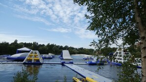 An outdoor water park with inflatable slides and play structures.