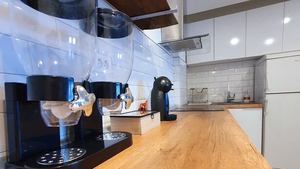 A modern kitchen with a wooden countertop, a coffee machine, a kettle, and a toaster. - Duplex 150m2 - Central Station best location in town (Skopje)