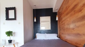 A bedroom with a bed, wooden headboard, bedside tables, a potted plant, and a window. - Duplex 150m2 - Central Station best location in town (Skopje)