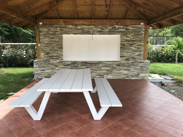 Relax in this serene outdoor patio area with a picnic table and stone wall.