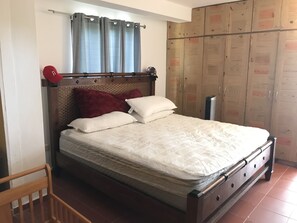 Cozy retreat with a large bed, wooden headboard, and wardrobe.