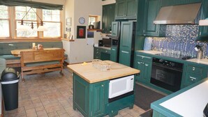 A kitchen with green cabinets, a wooden island, a microwave, an oven, and a sink. - Ski-in/Ski-out Access Quiet location at end of Cul-de-Sac (203048-9004) (Snowmass Village)