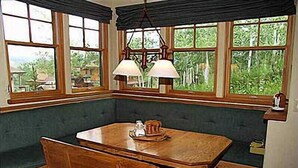 A corner room with a wooden bench, a table, and a hanging lamp. - Ski-in/Ski-out Access Quiet location at end of Cul-de-Sac (203048-9004) (Snowmass Village)