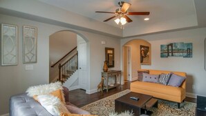 A spacious living room with a sofa, armchairs, a coffee table, and a ceiling fan. - July Fun! Happy & Chill in West Nashville! (Nashville)