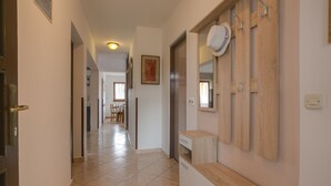 A hallway with a wooden cabinet, a white countertop, and a door with a keyhole. - Cozy apartment only 500m from the beach (Štinjan)