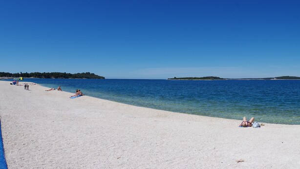 A beach with clear blue water and a sandy shore. - Cozy apartment only 500m from the beach (Štinjan)