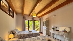 Une chambre avec deux lits, une commode, un miroir et une vue sur la verdure.