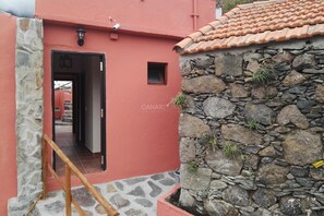 Ein rotes Gebäude mit einer Steinwand und einem Ziegeldach.