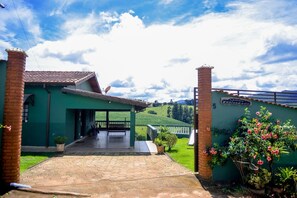Un edificio con una entrada cubierta, una chimenea de ladrillo y un letrero que dice "Felicidade".