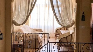 A bedroom with a canopy bed, a small table with a lamp, and a chair. - Il- Liedna Farmhouse with private pool and beautiful views..................... (Gharb)