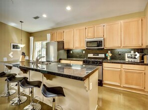 Enjoy cooking in this well-equipped kitchen with a large island and stainless steel appliances.