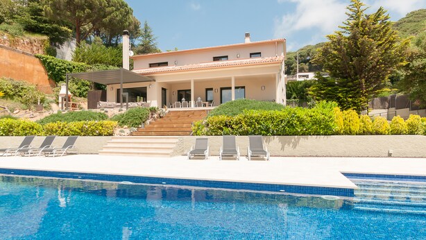 A modern house with a swimming pool, a covered patio, and a hillside view. -  Spacious family villa with pool, sea view, sauna, 10-14 persons (Sant Andreu de Llavaneres)