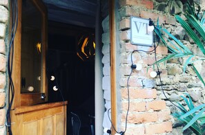 A wooden door with a mirror, a sign with 'VT' on it, and a stone wall with plants. - Rural apartment, special for families and pets, river and mountain views. (Zeberio)