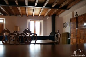 A rustic dining area with wooden furniture and a high ceiling.