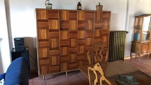 A living room with a wooden partition, a blue sofa, a wooden chair, and a radiator. - Casa de la Maestra for 10 people (Barbolla)