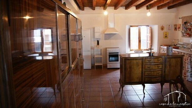 A kitchen with wooden cabinets, a stove, and a window. - Casa de la Maestra for 10 people (Barbolla)