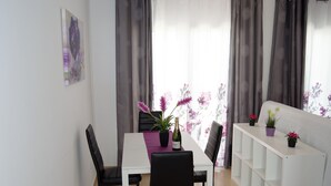 A dining area with a white table, black chairs, and a white shelving unit. - Cozy apartment in Muelle Deportivo Morro Jable, pets are allowed. (Morro Jable)