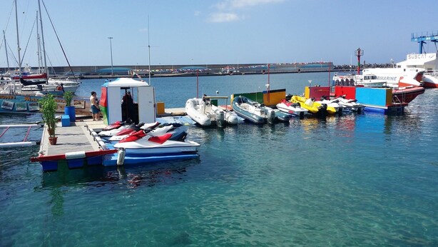 A marina with various boats docked, a small structure with a roof, and a clear view of the water. - Cozy apartment in Muelle Deportivo Morro Jable, pets are allowed. (Morro Jable)