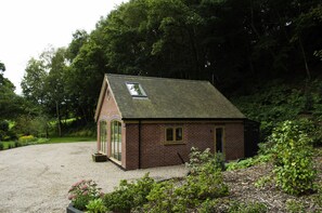 Un petit bâtiment en briques, doté d’un toit en pente, d’une fenêtre et d’une porte.