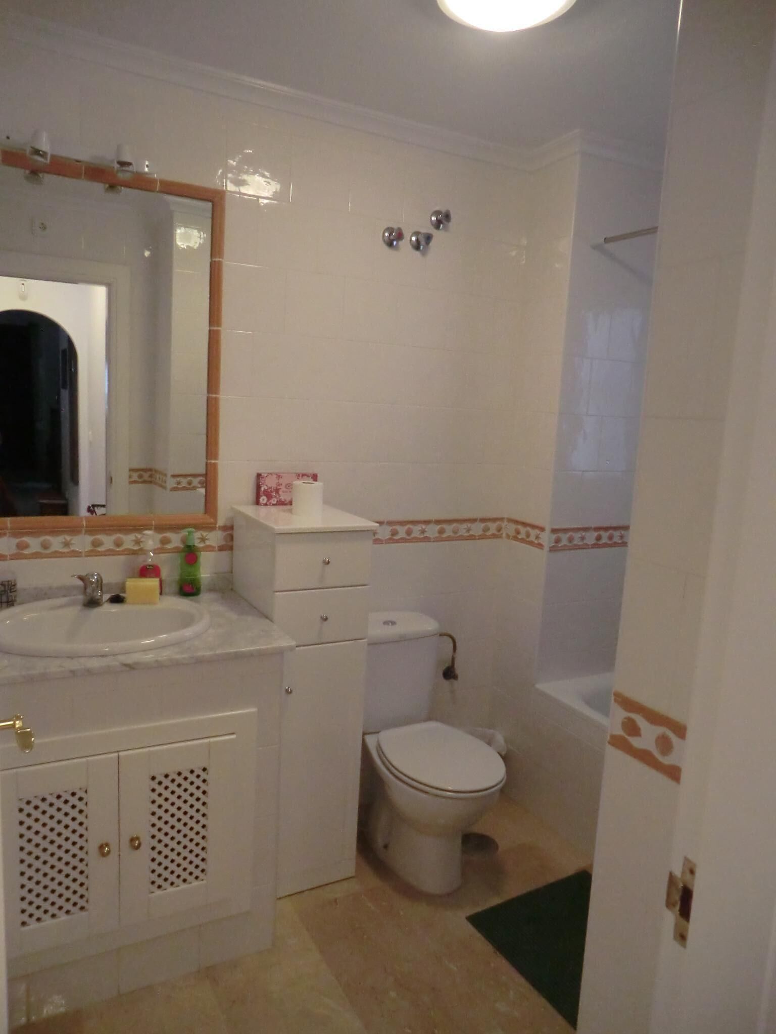 Een badkamer met wastafel, spiegel, toilet en douche.