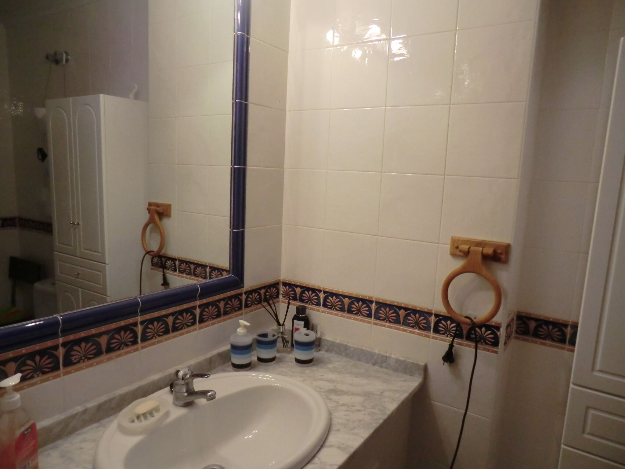 Une salle de bain équipée d’un lavabo, d’un miroir et d’articles de toilette.