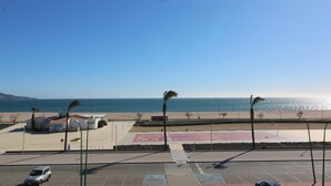 A parking lot with a basketball court, a building with a sign, and a beach in the background. - Three bedroom apartment with sea views (Empuriabrava)