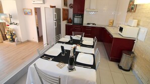 A compact kitchen with a dining area, equipped with a refrigerator, oven, microwave, and a sink. - Three bedroom apartment with sea views (Empuriabrava)