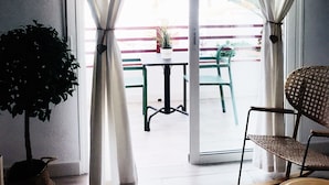 A room with a sliding glass door, a small table with a potted plant, and two chairs. - Cozy and comfortable, best location! Ideal for families. (Costa Adeje)